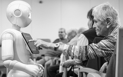 Ältere Frau berührt Tablet an humanoidem Roboter in Gemeinschaftsraum